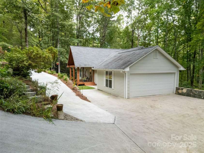 557 Country Club Estates Drive, Sapphire, NC 28774.  MLS# CAR4302980, YatesRealty ID 2977. The double car detached garage is accessible from two different driveways coming from the culdesac at the end of the paved Country Club Estates Drive. There's a lot of parking available next to the garage as w