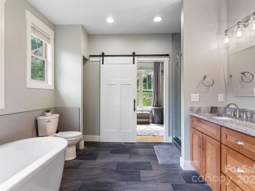 19 Carrolls Place Court, Mills River, NC 28759.  MLS# CAR4282064, YatesRealty ID 29890. Primary bathroom with freestanding tub and access to walk-in closet