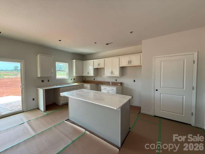 4025 Juno Drive, Charlotte, NC 28215.  MLS# CAR4392685, YatesRealty ID 29894. Kitchen features white surround cabinets and a gray island
