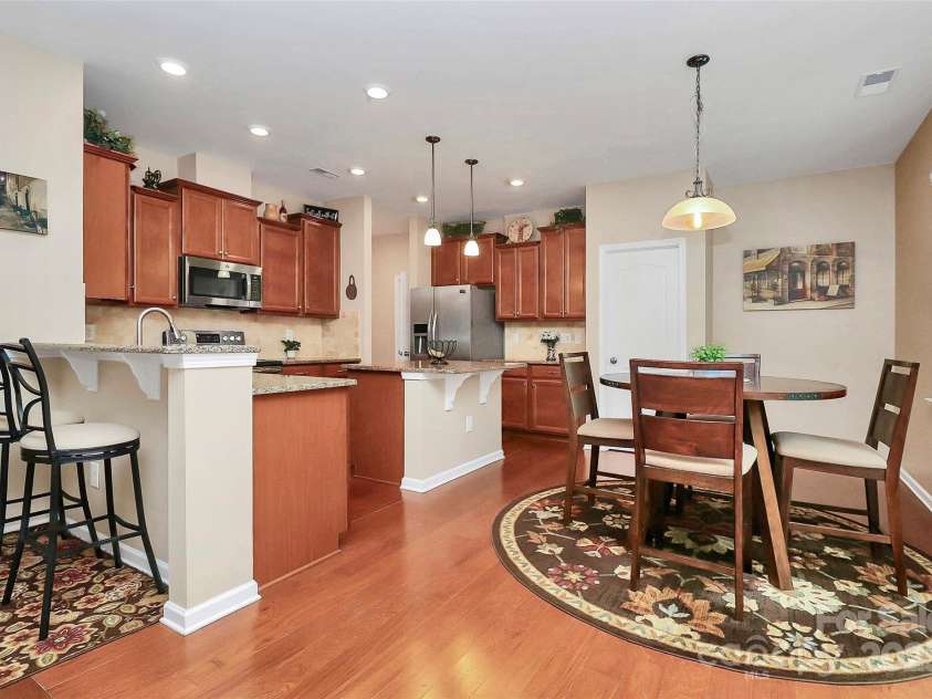 10369 Hillsborough Street, Huntersville, NC 28078.  MLS# CAR4283679, YatesRealty ID 29924. Hardwoods, breakfast bar, granite, breakfast room, tile back splash, nice cabinets, stainless appliances, island in nice size kitchen overlooking backyard.
