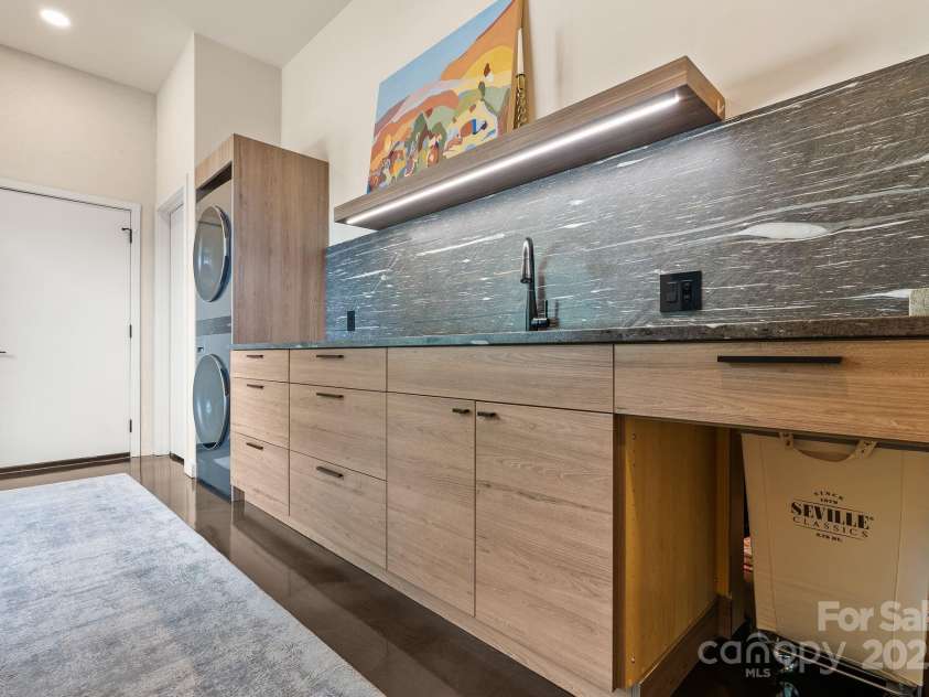 1045 & 1047 Graham Road, Marshall, NC 28753.  MLS# CAR4280943, YatesRealty ID 29941. Laundry room w/laundry basket that goes between primary closet