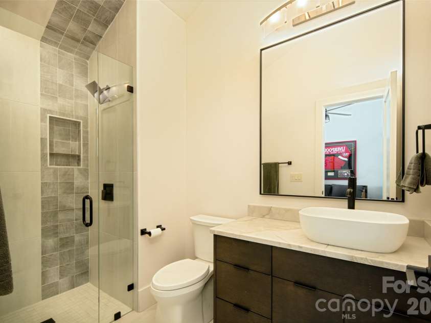 42 Spring Cove Road, Asheville, NC 28804.  MLS# CAR4246585, YatesRealty ID 29948. First of two full baths on second floor features vanity with vessel sink and custom-tiled shower.