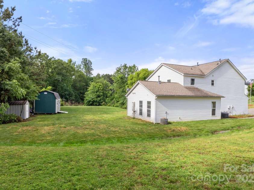 100 Brookstone Drive, Mount Holly, NC 28120.  MLS# CAR4256317, YatesRealty ID 29985. Back of house w/ 2 storage sheds