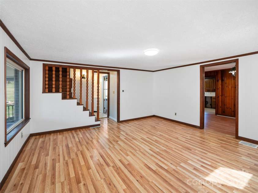 384 Flat Creek Road, Fairview, NC 28730.  MLS# CAR4240696, YatesRealty ID 2999. Living room with stairs to upstairs storage room
