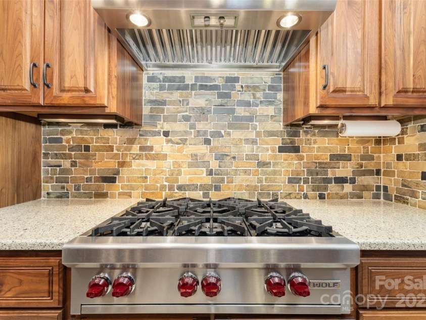 7063 Shenandoah Drive, Fort Mill, SC 29707.  MLS# CAR4278776, YatesRealty ID 30047. Wolf 6-burner gas stove w/commercial ventilation system