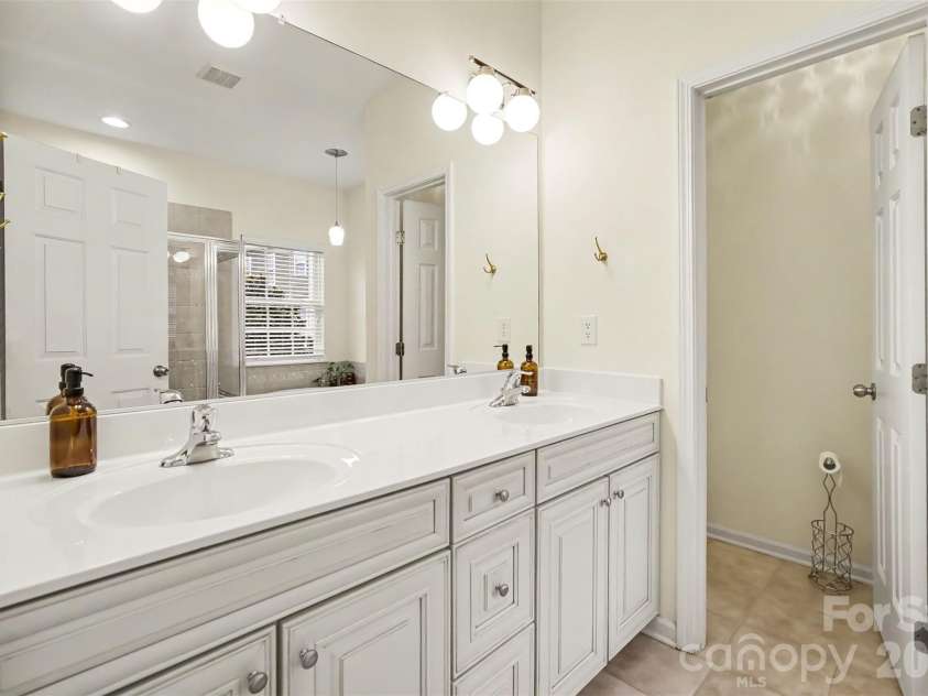 438 Magnolia Street, Davidson, NC 28036.  MLS# CAR4368147, YatesRealty ID 30083. Primary bath with dual vanity, tile flooring, neutral colors