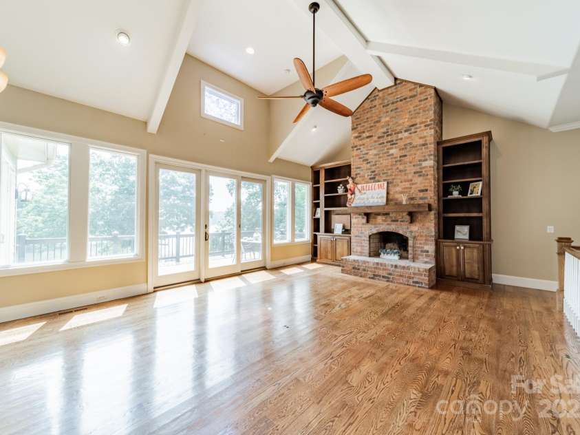 221 Stillwater Road, Troutman, NC 28166.  MLS# CAR4255773, YatesRealty ID 30097. Bright, gorgeous views from this very comfortable, open room with fireplace, site-finished, natural wood floors, plus adjoining kitchen and sunsoom