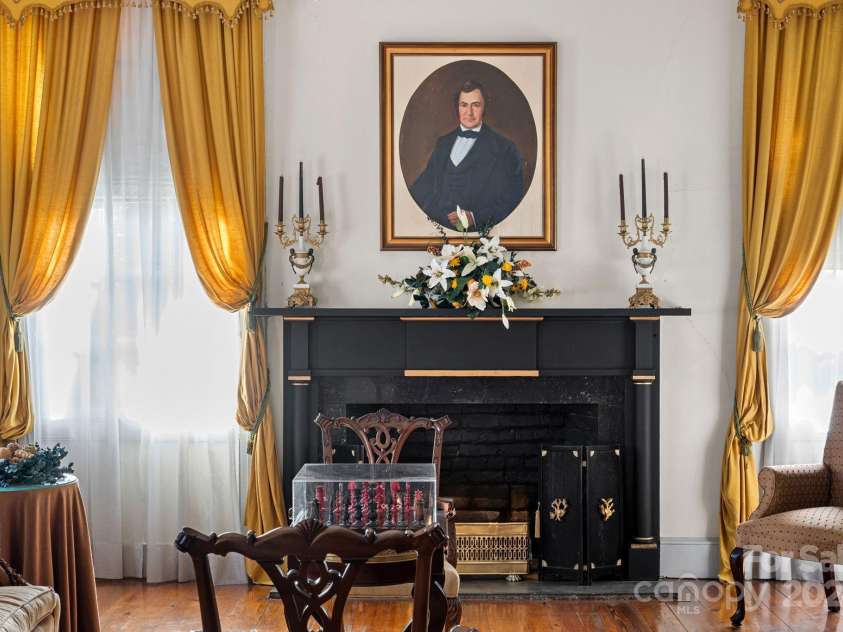 104 Leslie Loop, Mooresville, NC 28115.  MLS# CAR4195674, YatesRealty ID 301. A portrait of Major Rufus Reid, for whom this home was built, sits above the fireplace in the front Parlor