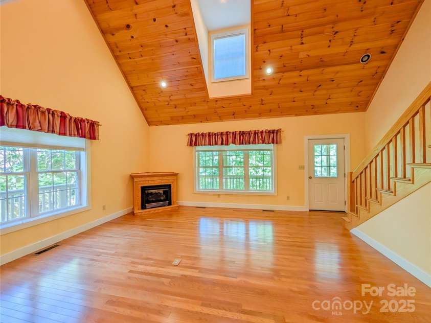 355 Rosewood Lane, Burnsville, NC 28714.  MLS# CAR4263679, YatesRealty ID 30113. 2 Story Great Room w/large picture window, gas log fireplace, tongue & groove ceiling, recessed lighting & skylight. Sunshine bright space to relax & enjoy w/access to covered porch.