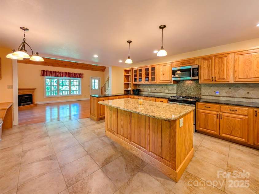 355 Rosewood Lane, Burnsville, NC 28714.  MLS# CAR4263679, YatesRealty ID 30113. This chef's kitchen includes granite countertops, kitchen island w/additional storage & built in wine rack, gas range & more!