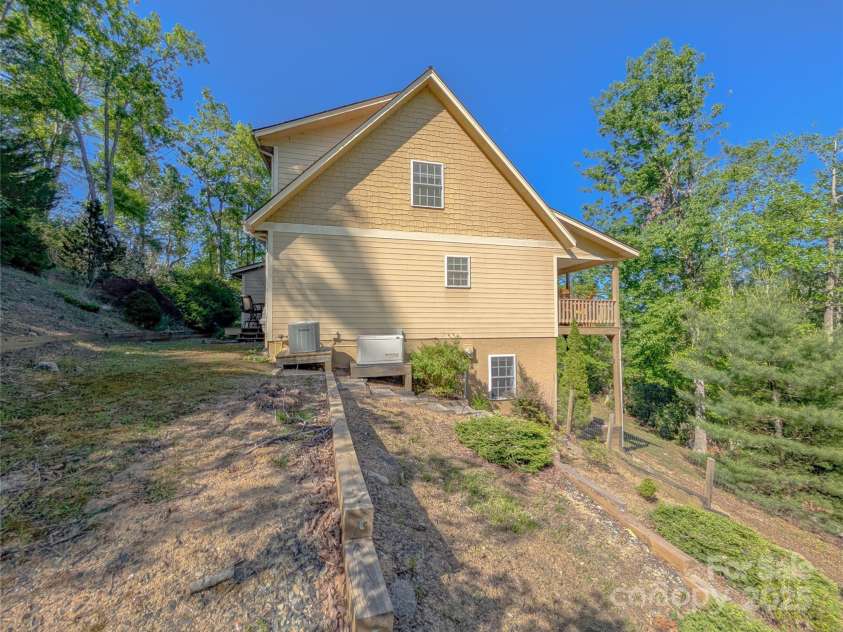 355 Rosewood Lane, Burnsville, NC 28714.  MLS# CAR4326302, YatesRealty ID 30113. View from back side of property - also included with property is a whole-house generator! Graduated landscaping offers potential for garden space! The acreage is mostly steep to sloping but provides a lovely private woo