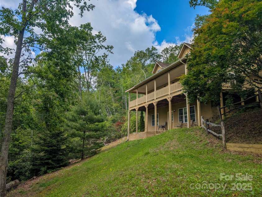 355 Rosewood Lane, Burnsville, NC 28714.  MLS# CAR4326302, YatesRealty ID 30113. View of Front of home from front yard. Topography of acreage is mostly steep/sloping but provides a nice private wooded setting!