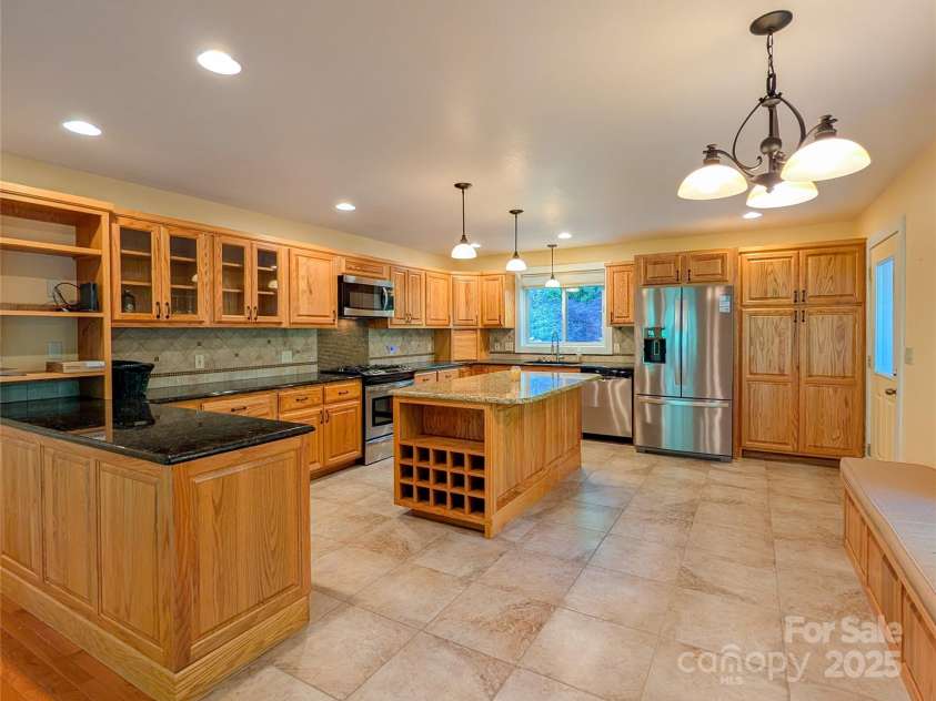 355 Rosewood Lane, Burnsville, NC 28714.  MLS# CAR4326302, YatesRealty ID 30113. You will LOVE the spacious chef's kitchen with granite countertops, plentiful cabinetry/storage, kitchen island with additional storage & built-in wine rack, the bench even opens up for additional storage & more! 