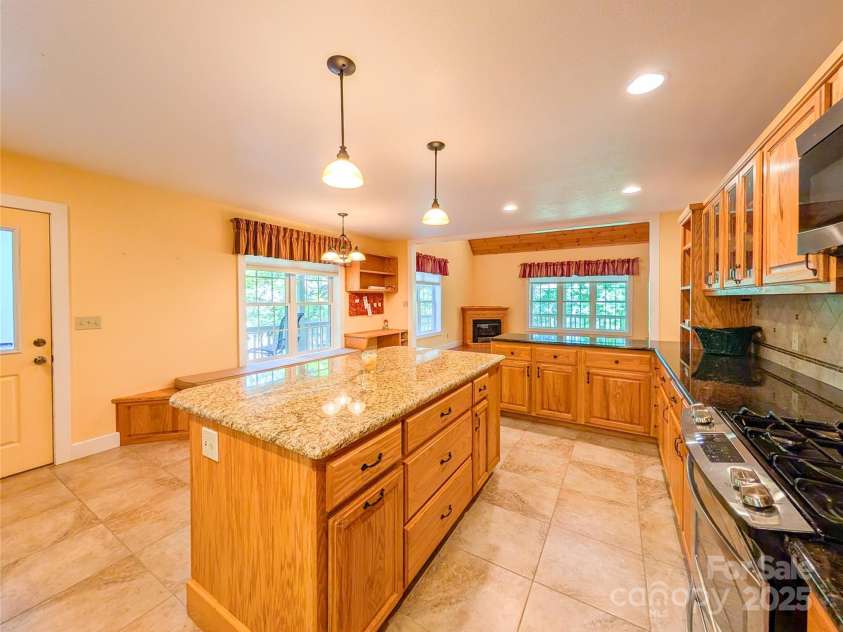 355 Rosewood Lane, Burnsville, NC 28714.  MLS# CAR4326302, YatesRealty ID 30113. You will LOVE the spacious chef's kitchen with granite countertops, plentiful cabinetry/storage, kitchen island with additional storage & built-in wine rack, the bench even opens up for additional storage, tile backspla
