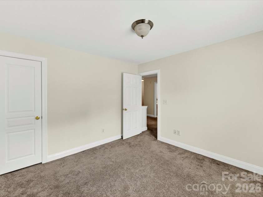 10507 Glenmeade Road, Cornelius, NC 28031.  MLS# CAR4391607, YatesRealty ID 30154. Spacious secondary bedroom offers comfortable accommodations with ample closet space, soft natural light, and a versatile layout to suit a variety of needs.
