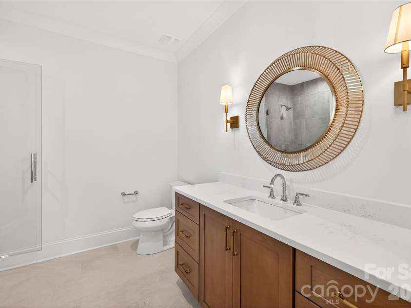 1316 Holmes Drive, Charlotte, NC 28209.  MLS# CAR4338664, YatesRealty ID 3016. Bathroom #4 in-suite with gold round mirror, pretty white tile in the white shower.