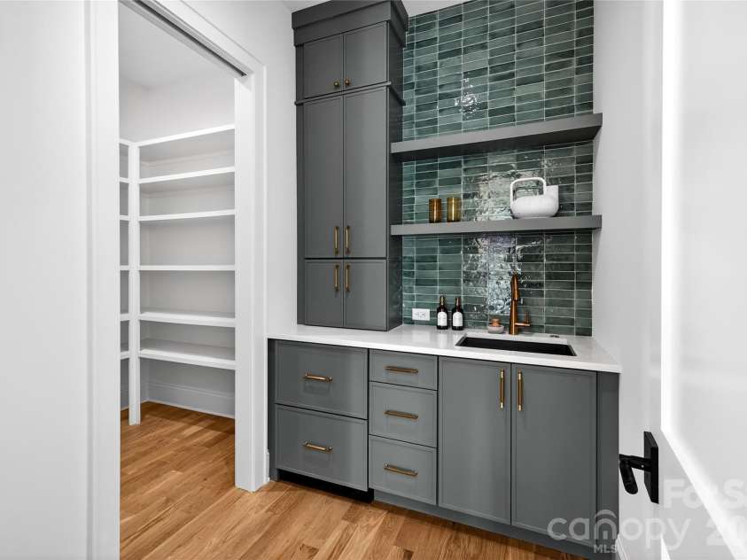 1316 Holmes Drive, Charlotte, NC 28209.  MLS# CAR4338664, YatesRealty ID 3016. Walk-in Wet Bar. Beautiful glass tile backsplash. Drawers on bottom left are a refrigerator drawer and an ice drawer. Sink. To the left is the walk-in pantry with permanent shelves.