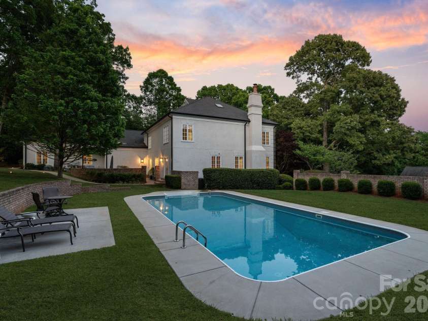 8124 Greencastle Drive, Charlotte, NC 28210.  MLS# CAR4364842, YatesRealty ID 30191. Backyard pool and lounge area at twilight.