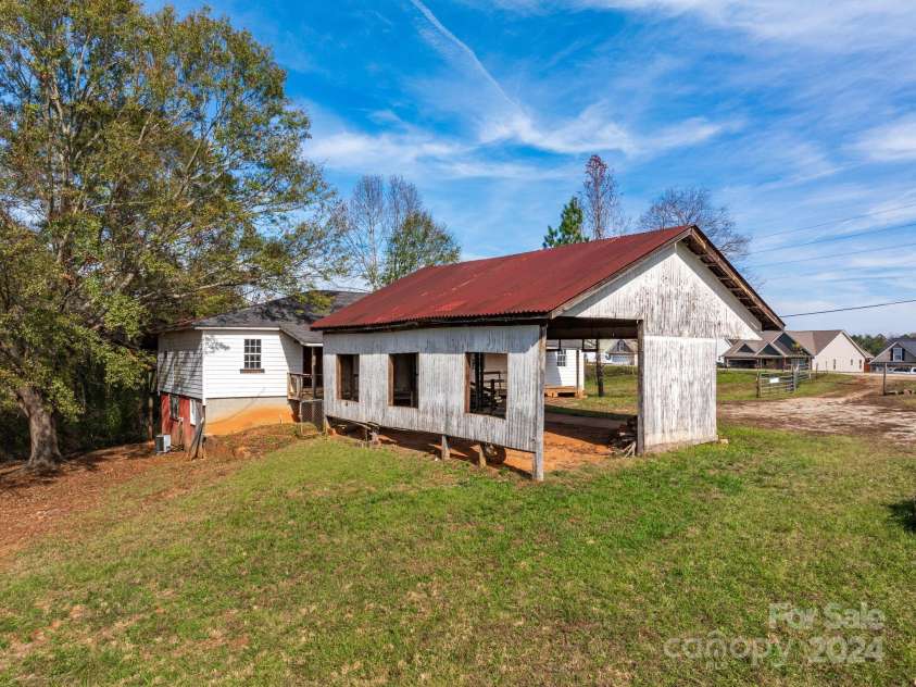 152 Long Branch Road, Chesnee, SC 29323.  MLS# CAR4204540, YatesRealty ID 302. Back view of the carport looking toward Long Branch Rd, there is a nice subdivision with newer homes and public water across the street. 
