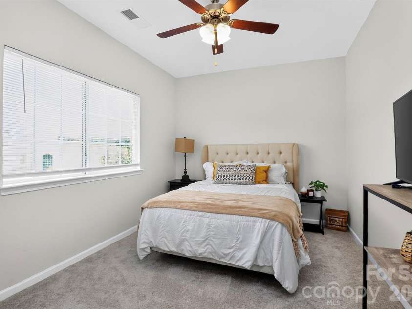 773 River Park Road, Belmont, NC 28012.  MLS# CAR4391220, YatesRealty ID 30213. Bright, Comfortable, and Ready to Personalize. Large windows fill this secondary bedroom with natural light, while neutral finishes and a ceiling fan create a comfortable retreat that's ready for your personal style.