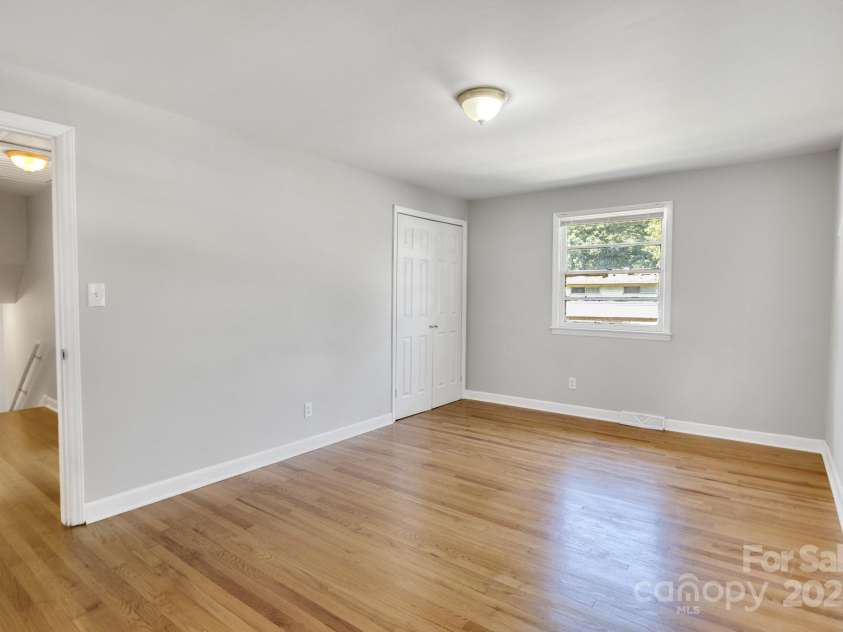4635 Thornwood Road, Charlotte, NC 28213.  MLS# CAR4276510, YatesRealty ID 30250. Walking into primary bedroom. Open door on left of photo leads to hall connecting all bedrooms. Closed door in center of photo opens to closet.