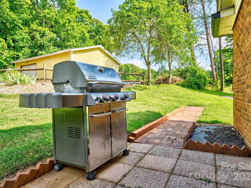 7753 Caswell Road, Stanley, NC 28164.  MLS# CAR4276529, YatesRealty ID 30264. Grilling area beside carport