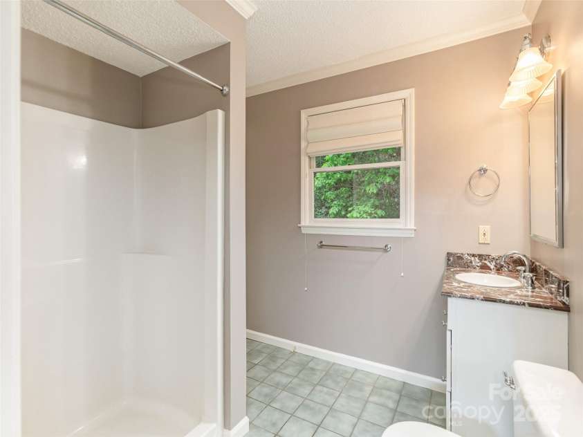 55 Willow Bend, Hendersonville, NC 28792.  MLS# CAR4255625, YatesRealty ID 30273. Main floor full bathroom with marble vanity top, walk in shower and tiled floor.