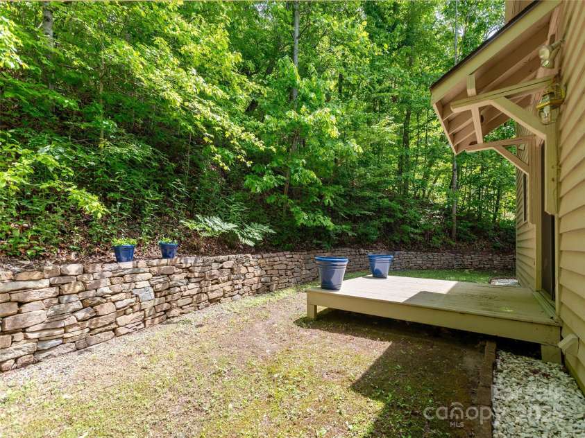 55 Willow Bend, Hendersonville, NC 28792.  MLS# CAR4255625, YatesRealty ID 30273. Private backyard with beautiful stone retaining wall.  Backs to private wooded area.
