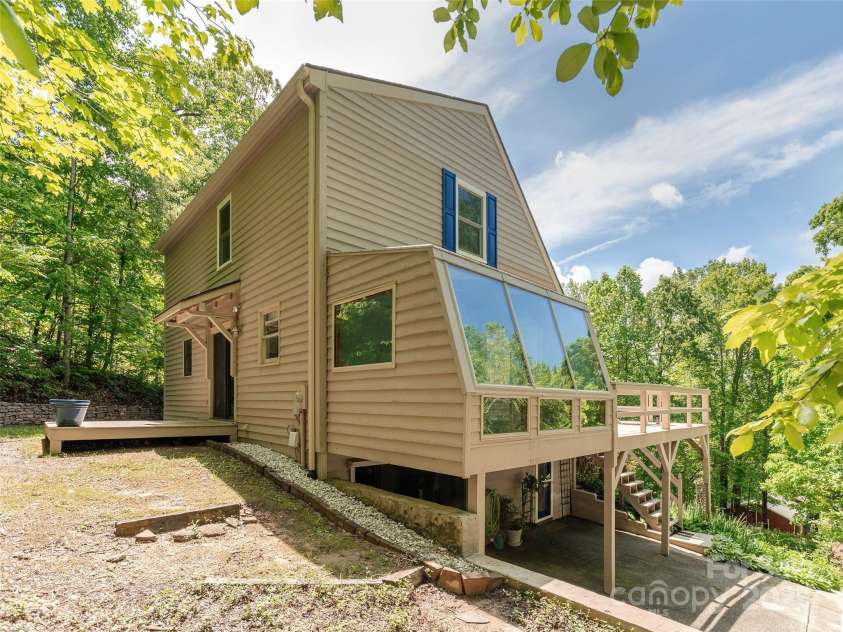 55 Willow Bend, Hendersonville, NC 28792.  MLS# CAR4255625, YatesRealty ID 30273. View of backyard showing sunroom on the side of the house.