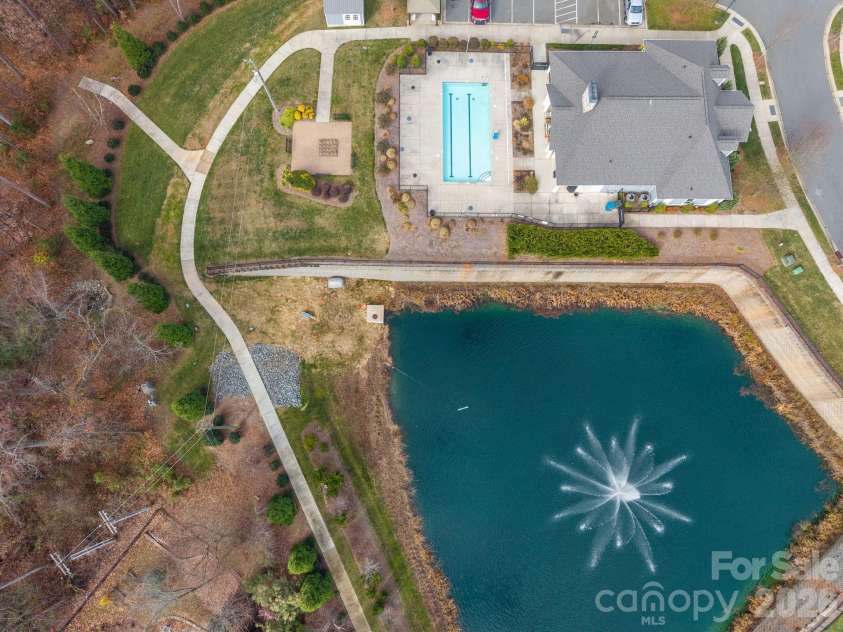 15012 Courtside Cove Lane, Cornelius, NC 28031.  MLS# CAR4326155, YatesRealty ID 30321. Aerial view of pond and community pool, clubhouse, and pocket park