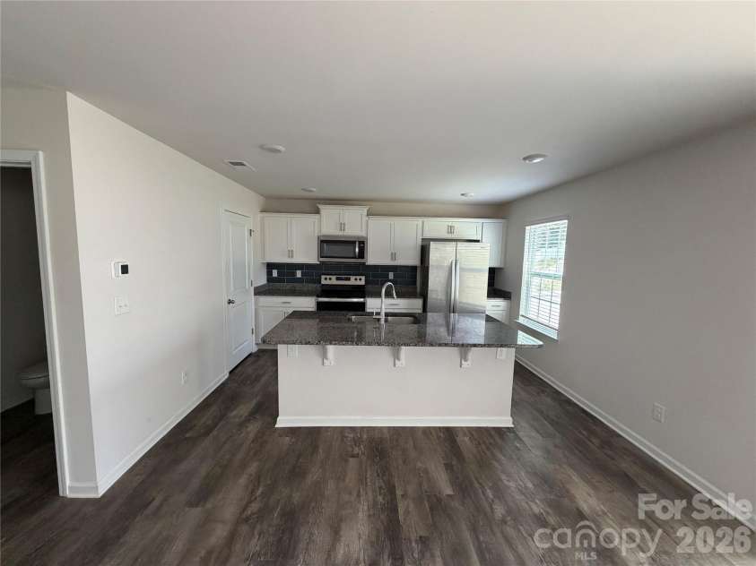 7868 Whispering Stream Drive, Sherrills Ford, NC 28673.  MLS# CAR4380726, YatesRealty ID 30352. Full kitchen with huge island with granite, half bath on left