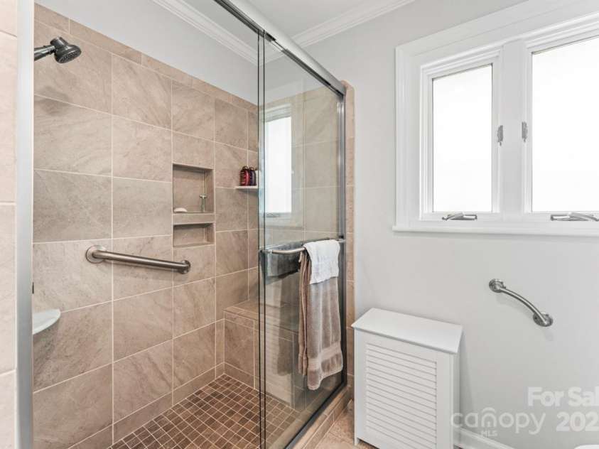 128 Killian Farm Road, Stanley, NC 28164.  MLS# CAR4288617, YatesRealty ID 30393. Oversized tile shower with shelves and bench seat