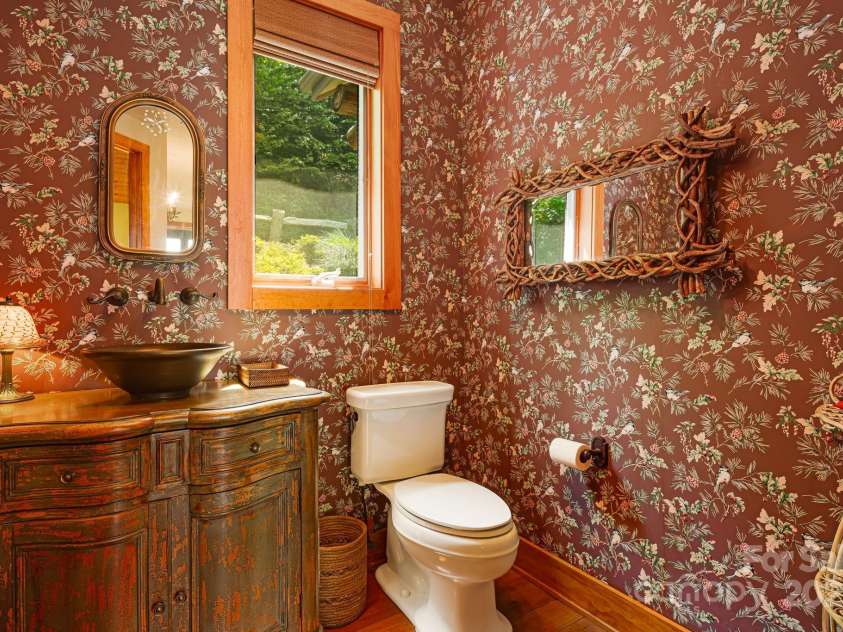 197 Cherry Knob Drive, Mars Hill, NC 28754.  MLS# CAR4271284, YatesRealty ID 30496. Charming half bath with custom vanity, vessel sink, and nature-inspired wallpaper—perfectly blending rustic elegance with mountain flair.