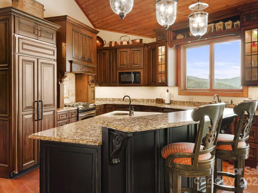 197 Cherry Knob Drive, Mars Hill, NC 28754.  MLS# CAR4271284, YatesRealty ID 30496. Chef’s kitchen features rich custom cabinetry, granite countertops, gas cooktop, copper sinks, and a picture-perfect mountain view framed by oversized windows.