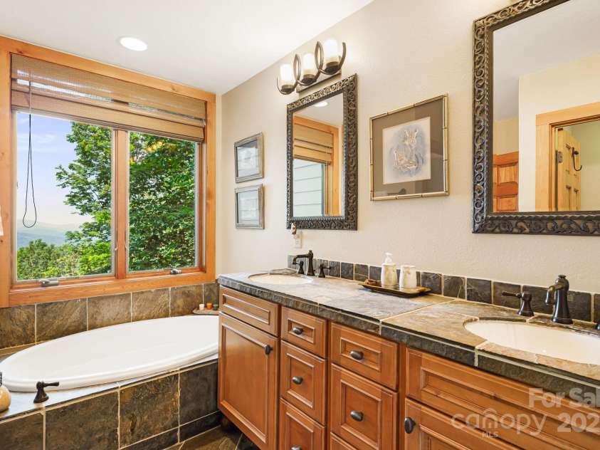 197 Cherry Knob Drive, Mars Hill, NC 28754.  MLS# CAR4271284, YatesRealty ID 30496. This en suite bath features a picture-perfect window over the tub for peaceful, scenic relaxation.