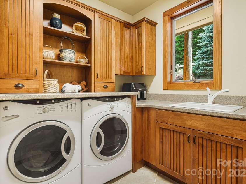 197 Cherry Knob Drive, Mars Hill, NC 28754.  MLS# CAR4271284, YatesRealty ID 30496. Warm wood cabinetry, built-in storage, and natural light elevate this laundry room into a welcoming and efficient workspace.