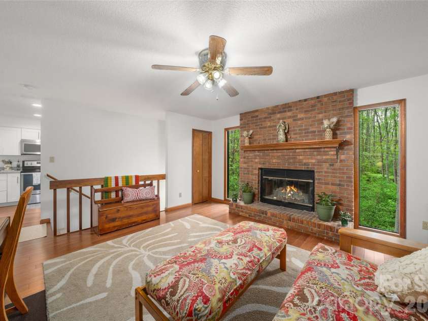 17 Morris Drive, Weaverville, NC 28787.  MLS# CAR4333064, YatesRealty ID 30498. To the right of the front door is the den/office with entrance to the kitchen and newly carpeted stairs that lead to the basement below. The brick fireplace features a handsome handmade wooden mantle above the Wood Burni