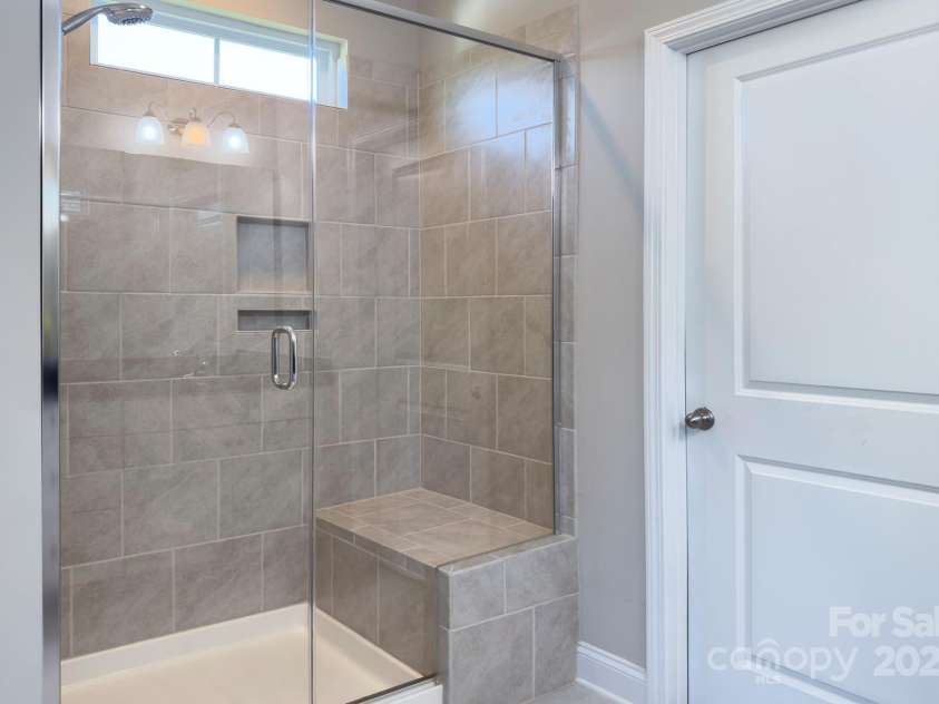 4333 Legacy Drive, Denver, NC 28037.  MLS# CAR4268766, YatesRealty ID 30506. Tiled shower with bench