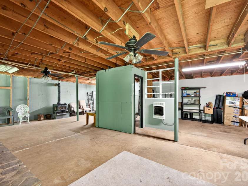 30 Reeves Drive, Burnsville, NC 28714.  MLS# CAR4391470, YatesRealty ID 30607. Basement Showing Wood Stove