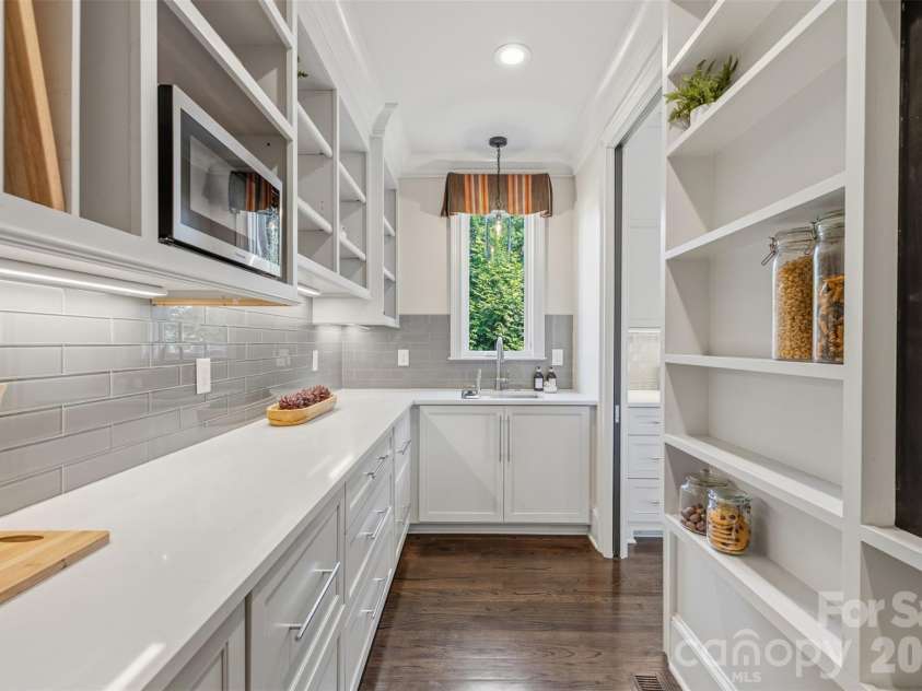18407 Peninsula Cove Lane, Cornelius, NC 28031.  MLS# CAR4391272, YatesRealty ID 30620. A fully appointed scullery enhances functionality with additional prep space, beverage drawers, extensive storage, and custom cabinetry, creating the perfect extension of the kitchen for hosting and organization.