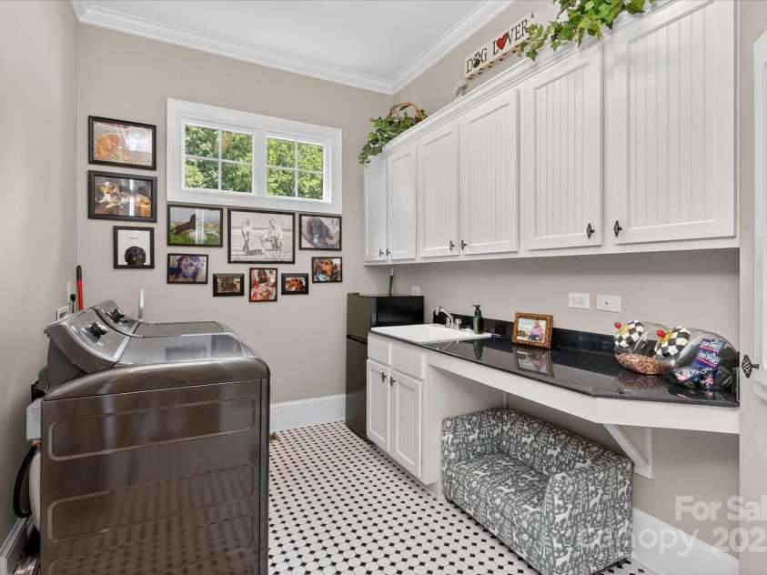 1100 Seminole Drive, Indian Land, SC 29707.  MLS# CAR4285132, YatesRealty ID 30711. Laundry room on main with storage cabinets, sink and pull out ironing board