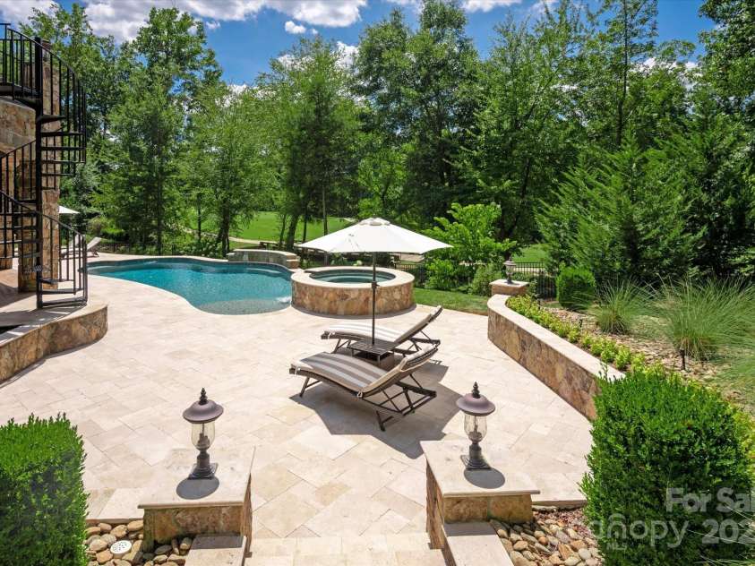 1100 Seminole Drive, Indian Land, SC 29707.  MLS# CAR4285132, YatesRealty ID 30711. Sprawling travertine pool decking surrounded by beautiful landscaping