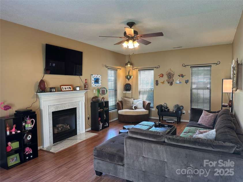 5845 Mahogany Place, Concord, NC 28025.  MLS# CAR4283667, YatesRealty ID 30850. Spacious living room with laminate wood floors and a gas fireplace