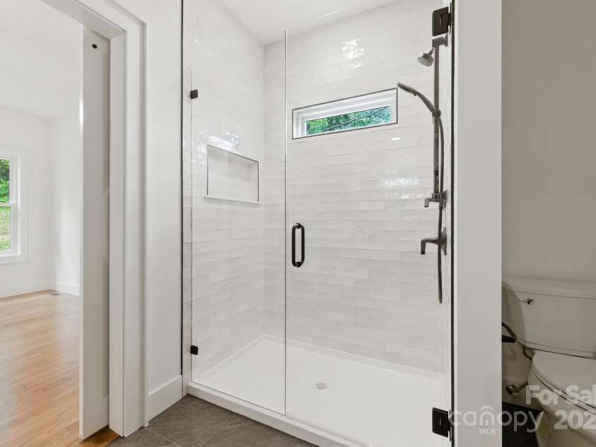 82 Lillycrop Lane, Hendersonville, NC 28792.  MLS# CAR4273359, YatesRealty ID 30864. Primary shower with tasteful floor to ceiling subway tile