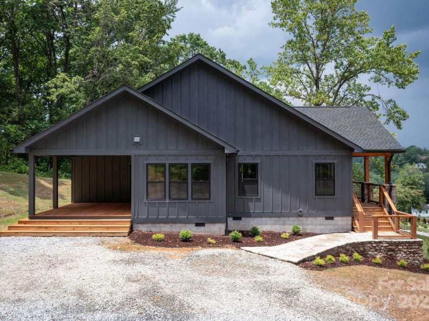 82 Lillycrop Lane, Hendersonville, NC 28792.  MLS# CAR4273359, YatesRealty ID 30864. Side view of the home showcasing ample parking space and beautiful landscaping that enhances curb appeal