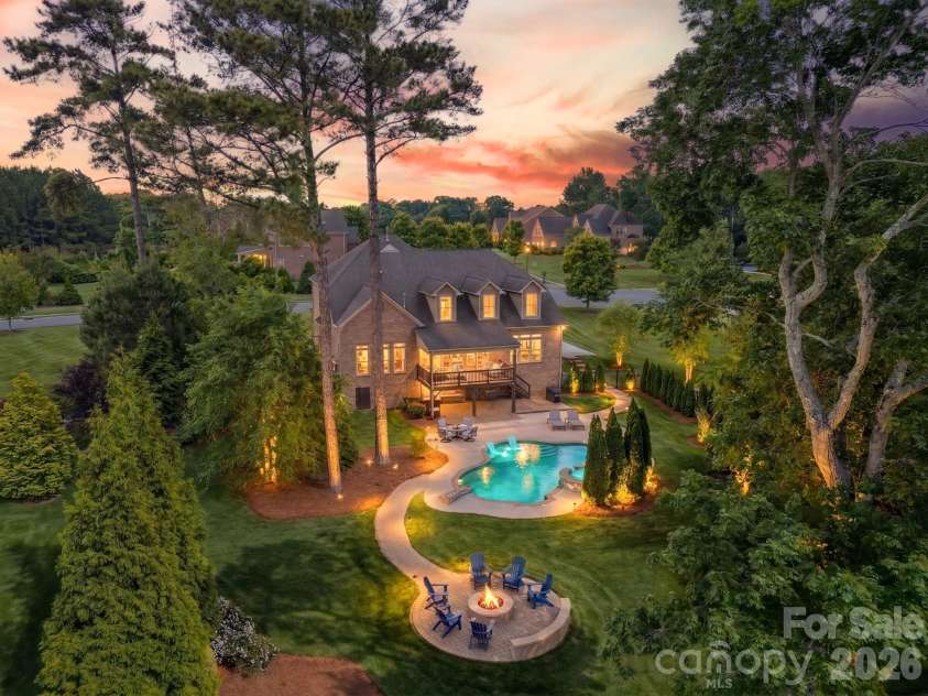 701 Copper Tree Lane, Waxhaw, NC 28173.  MLS# CAR4378056, YatesRealty ID 30870. Exceptional backyard with saltwater pool and spa, with tanning ledge and diving rock, firepit with gathering space, and a park-like setting with pond and fountain views.