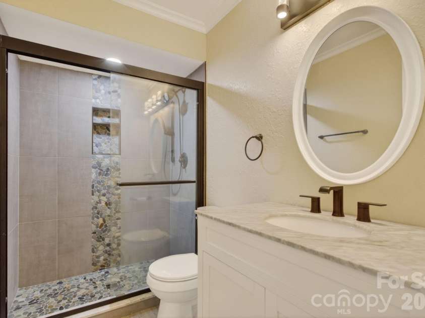 97 Whippoorwill Lane, Fairview, NC 28730.  MLS# CAR4377999, YatesRealty ID 30887. Guest bathroom on main level custom tile shower