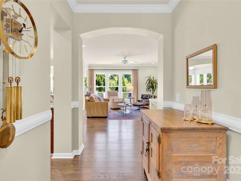 7028 Kitty Hawk Lane, Fort Mill, SC 29707.  MLS# CAR4285011, YatesRealty ID 30903. Front Door Entrance - wood floors, chair railing, arched entry, and the tree lined view.