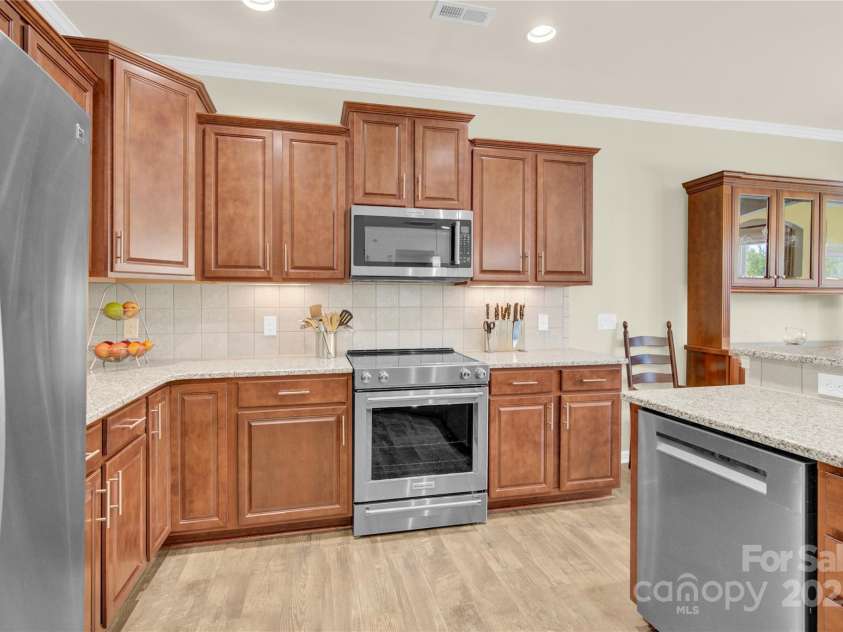 7028 Kitty Hawk Lane, Fort Mill, SC 29707.  MLS# CAR4285011, YatesRealty ID 30903. Kitchen w/under cabinet lighting, tile backsplash, soft close drawers, and stainless appliances.