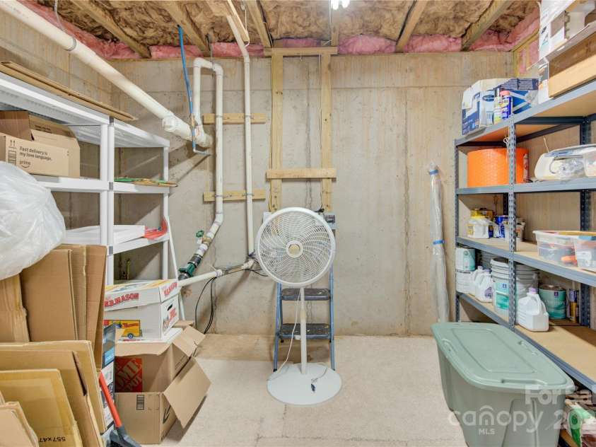 7028 Kitty Hawk Lane, Fort Mill, SC 29707.  MLS# CAR4285011, YatesRealty ID 30903. Walk-in Storage area in the climate controlled finished basement, including a dehumidifier. *The shelving remains.